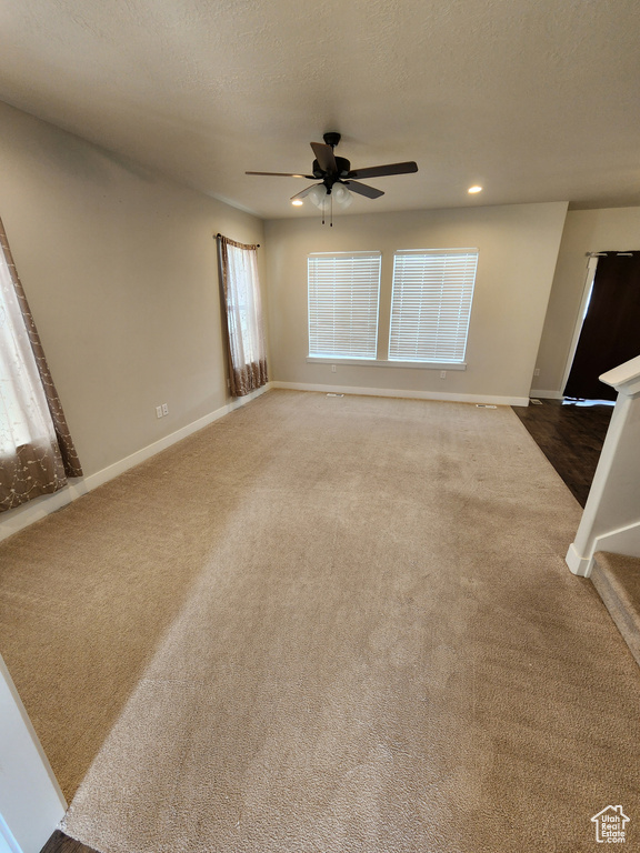 Unfurnished living room featuring carpet floors, a ceiling fan, baseboards, and recessed lighting
