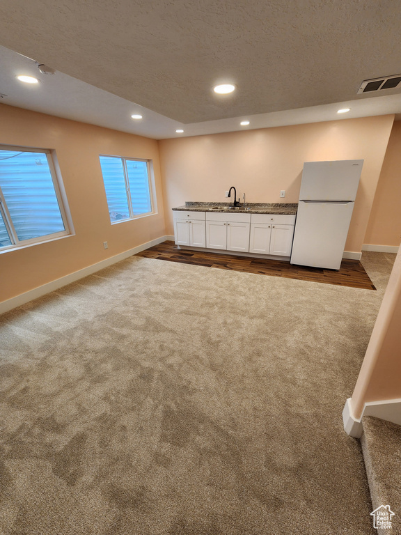 Interior space with dark carpet, baseboards, and indoor wet bar