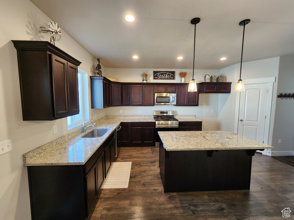 Kitchen with a center island, a sink, appliances with stainless steel finishes, and recessed lighting