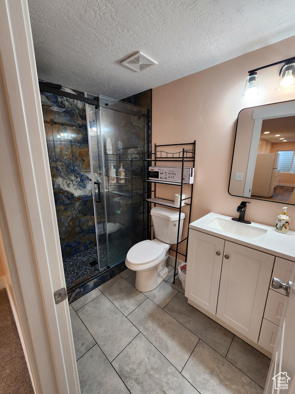 Bathroom with visible vents, vanity, toilet, a textured ceiling, and a shower stall