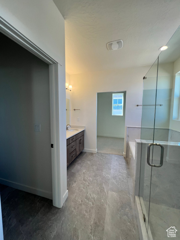 Bathroom featuring vanity, baseboards, a shower stall, and a bath