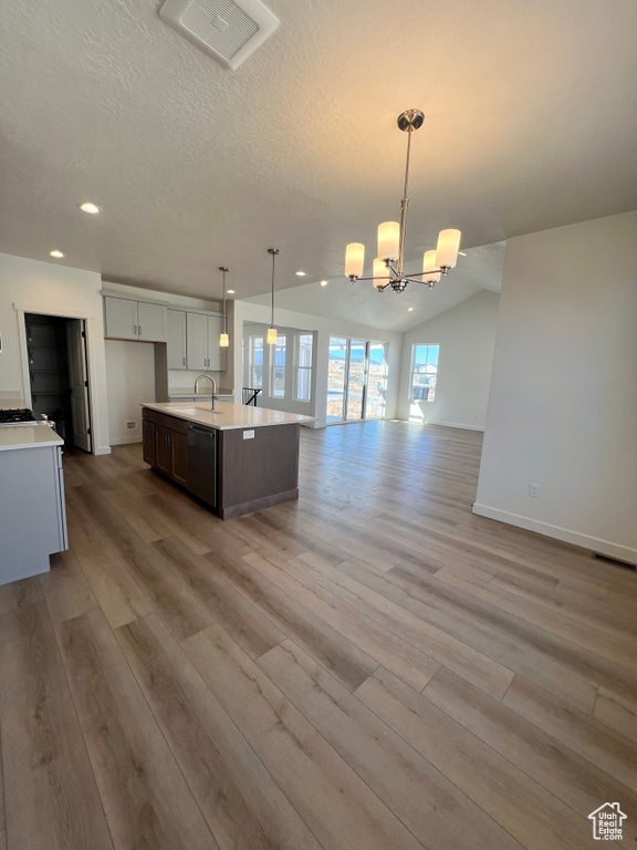 Kitchen with light countertops, open floor plan, a notable chandelier, and light wood finished floors
