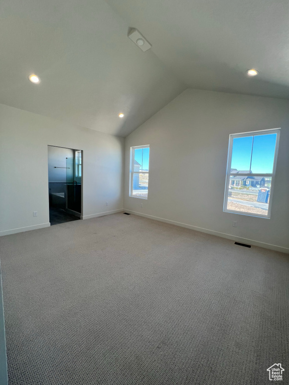 Empty room featuring baseboards, recessed lighting, lofted ceiling, and light carpet