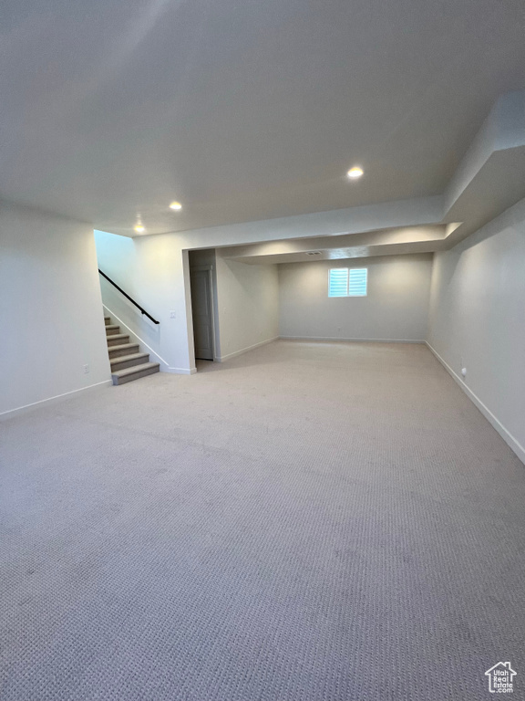 Basement featuring stairway, baseboards, and recessed lighting