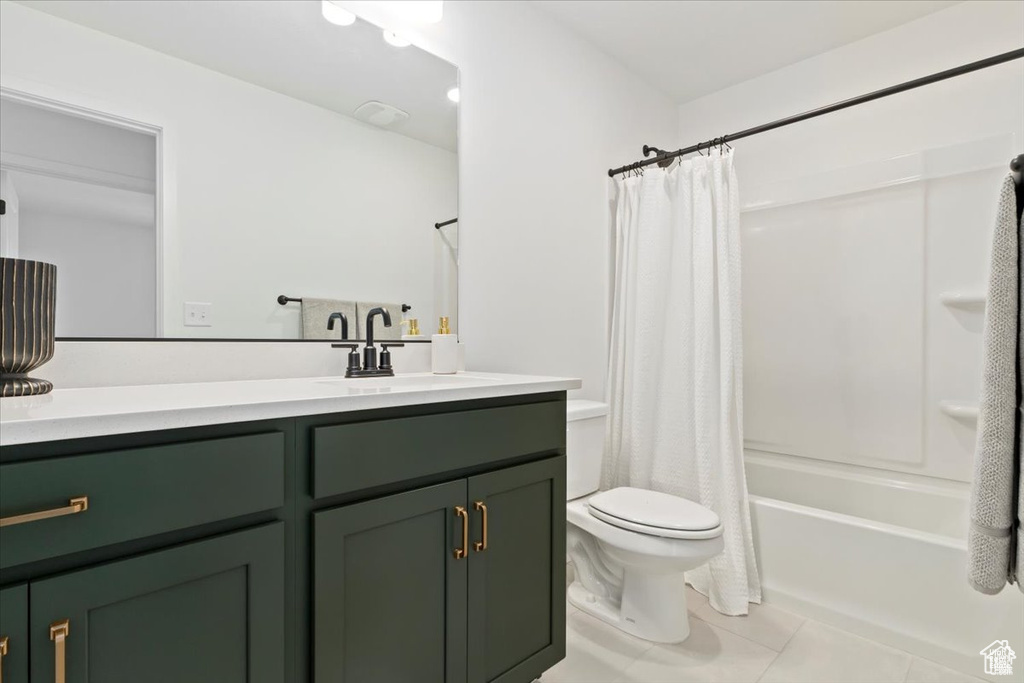 Bathroom featuring vanity, tile patterned flooring, toilet, and shower / tub combo with curtain