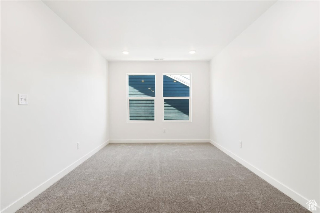 Carpeted spare room with baseboards and recessed lighting