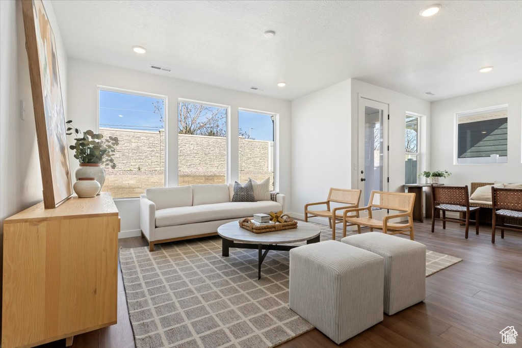 Living room with recessed lighting, wood finished floors, and visible vents
