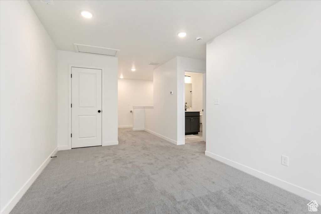 Spare room with baseboards, attic access, recessed lighting, and light colored carpet