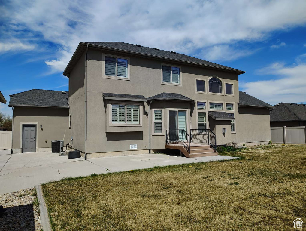 Rear view of property with a patio area, fence, cooling unit, a yard, and stucco siding