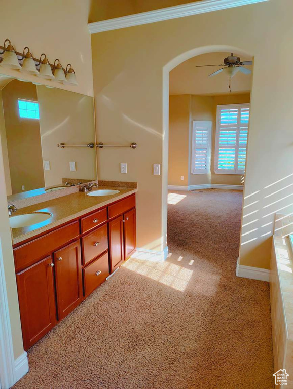 Bathroom with a sink, baseboards, a ceiling fan, and double vanity