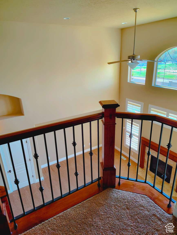 Staircase with ceiling fan and wood finished floors