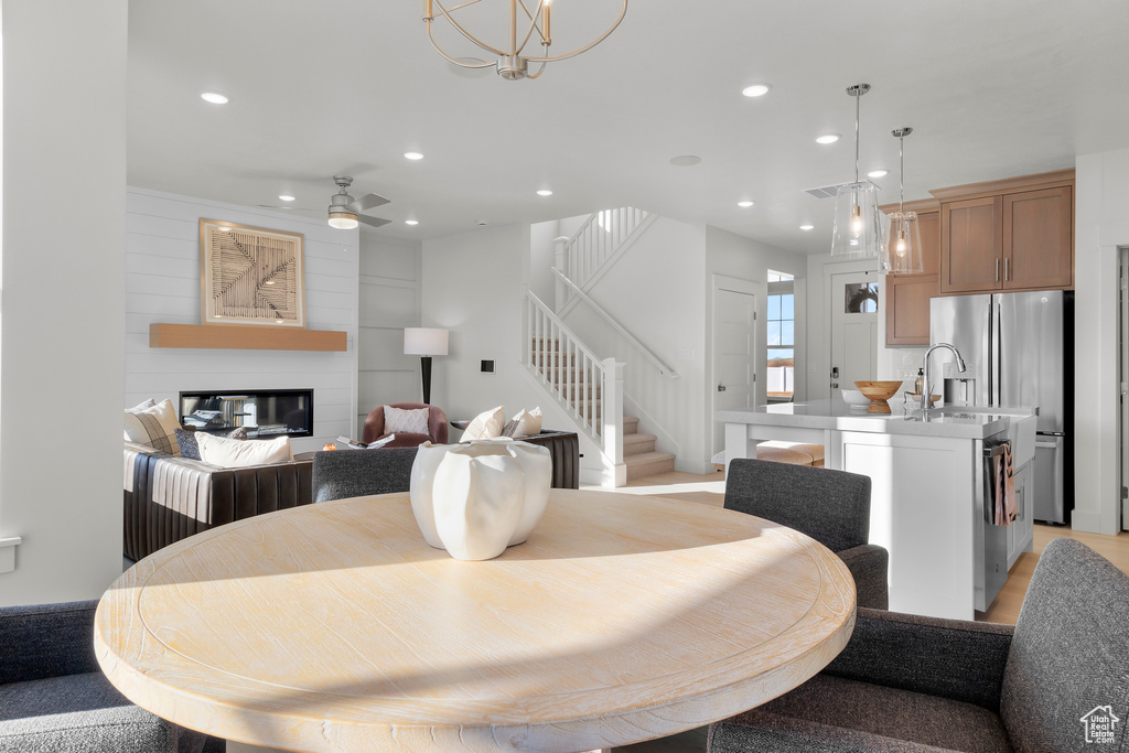 Dining area with visible vents, stairs, recessed lighting, a large fireplace, and a ceiling fan