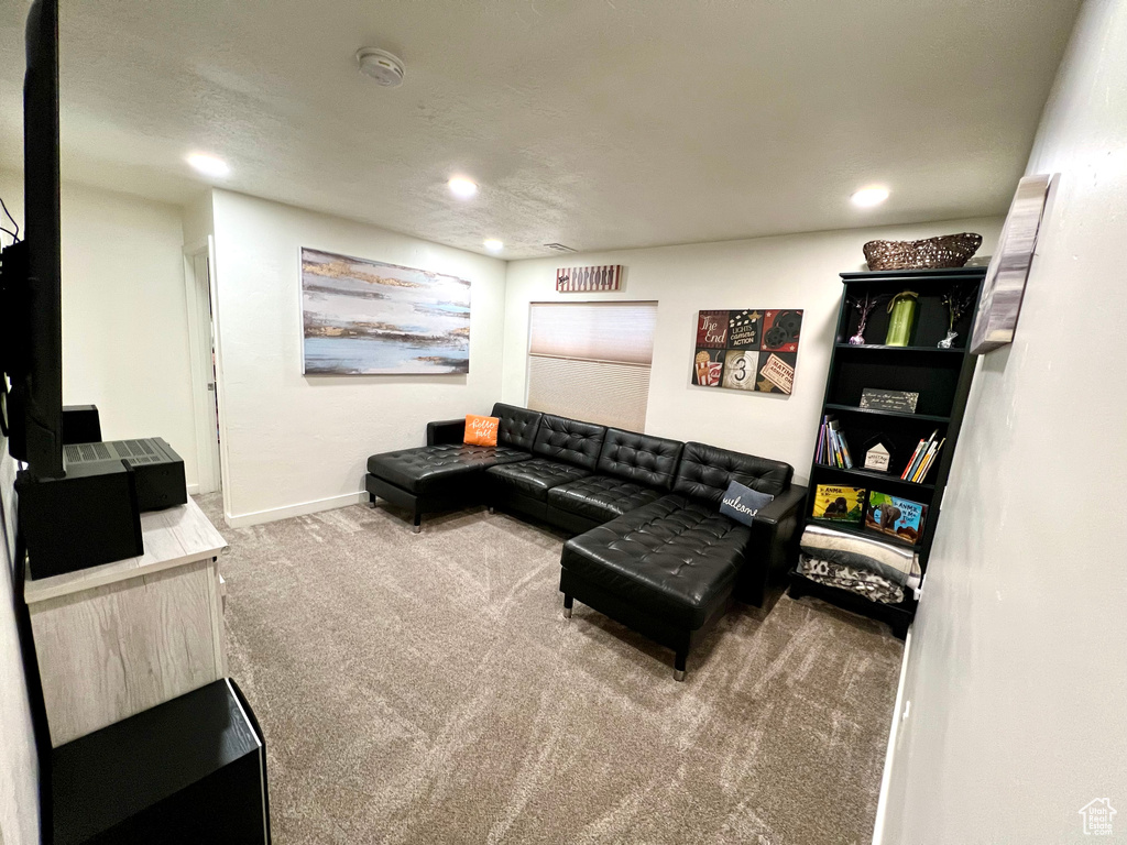 Carpeted living area featuring recessed lighting and baseboards