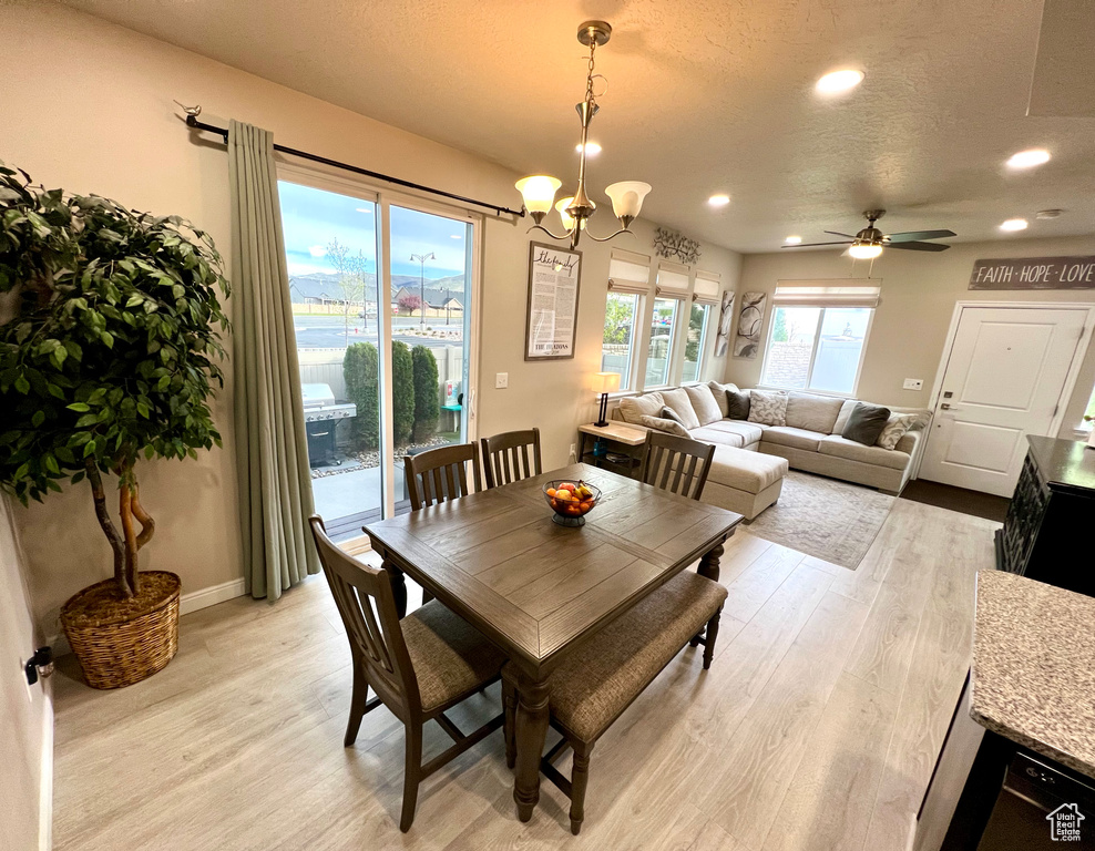Dining space featuring recessed lighting, a textured ceiling, ceiling fan with notable chandelier, and light wood-style floors