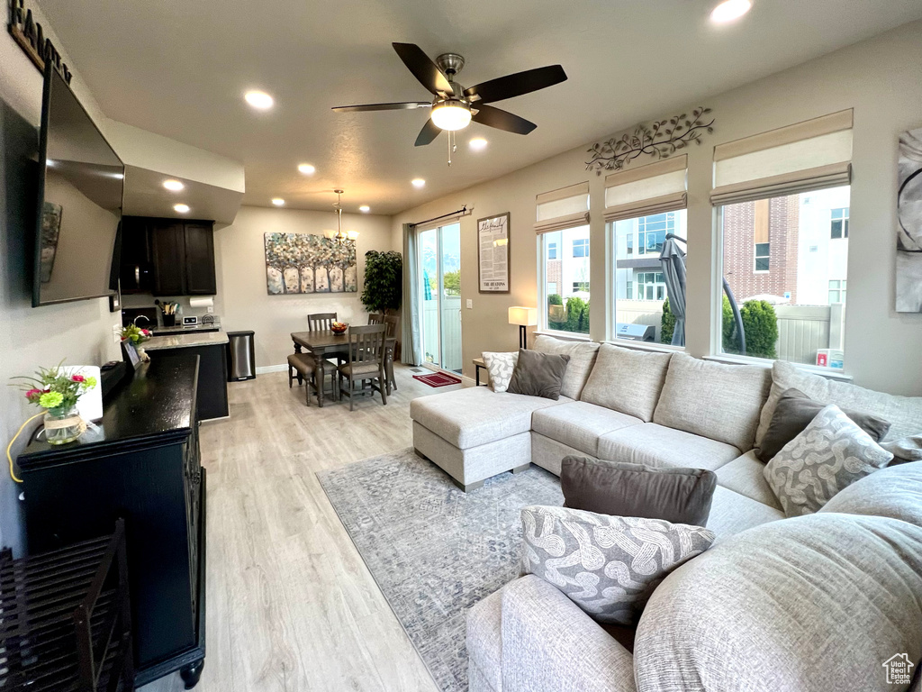 Living room featuring a ceiling fan, recessed lighting, and light wood finished floors