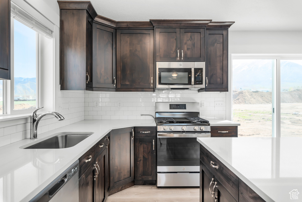 Kitchen with light countertops, stainless steel appliances, a healthy amount of sunlight, and a sink