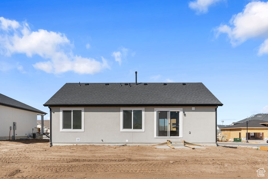 Rear view of property featuring a shingled roof and stucco siding
