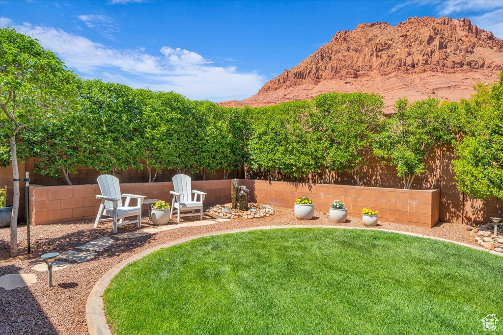View of yard with a mountain view and fence