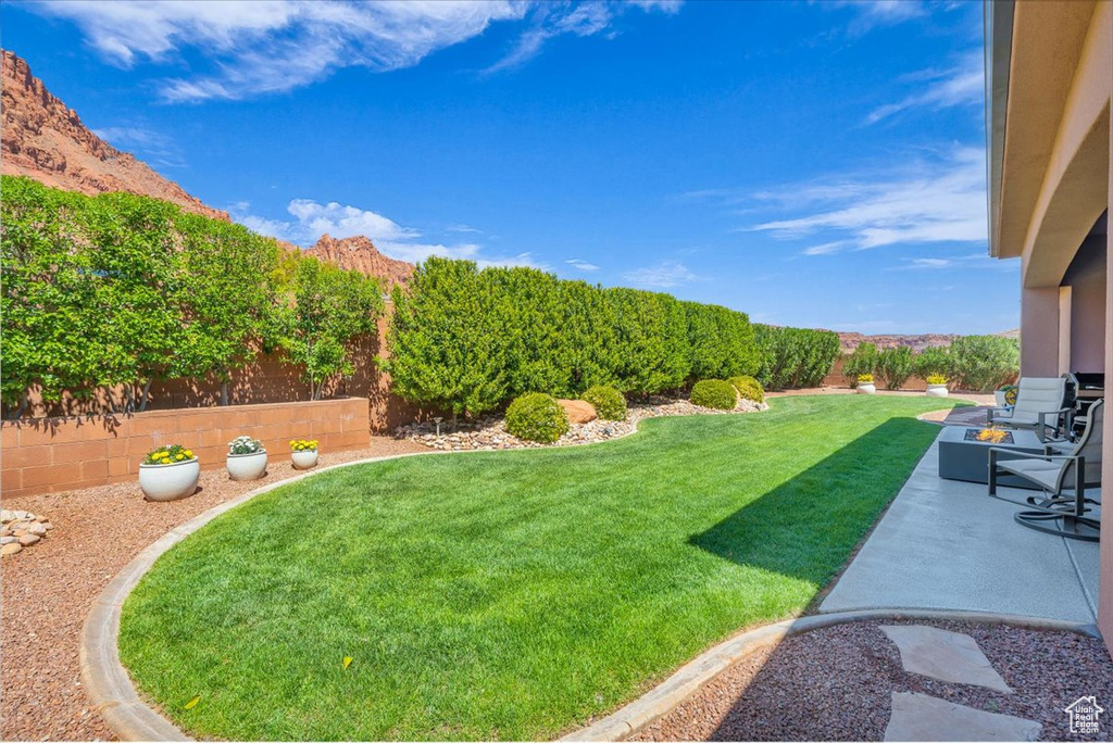 View of yard with a mountain view, a fenced backyard, and a patio area