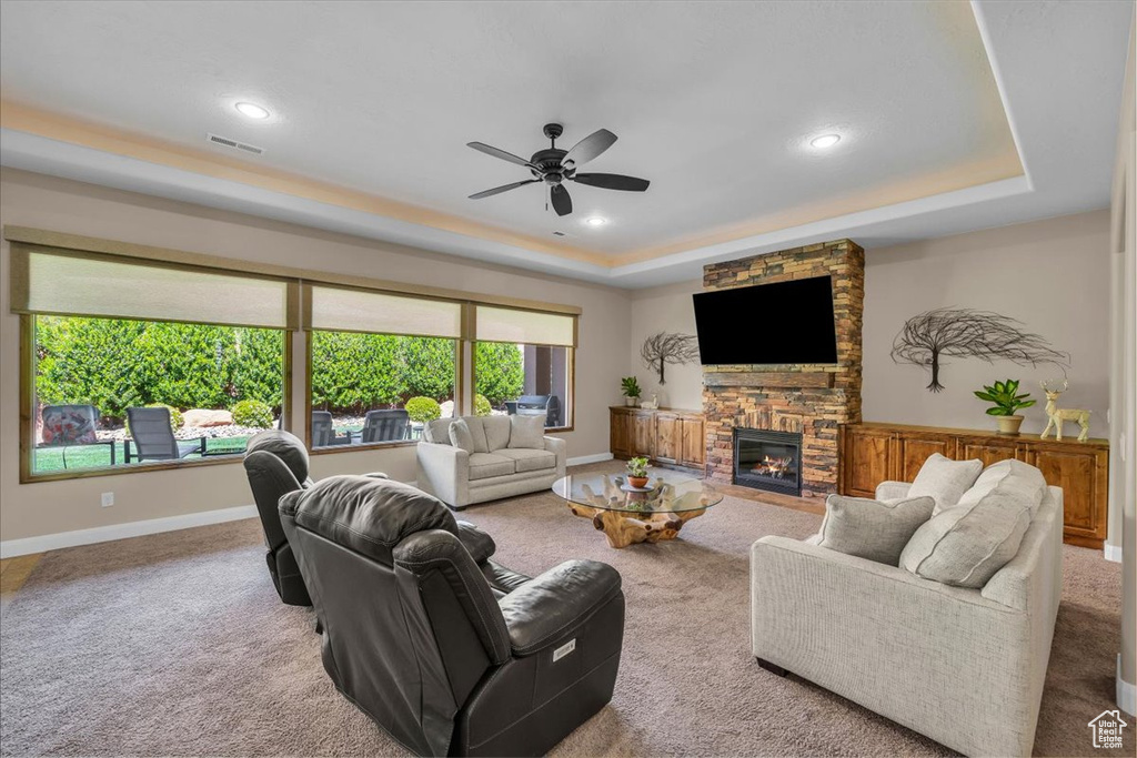 Living area with ceiling fan, carpet, a tray ceiling, and visible vents