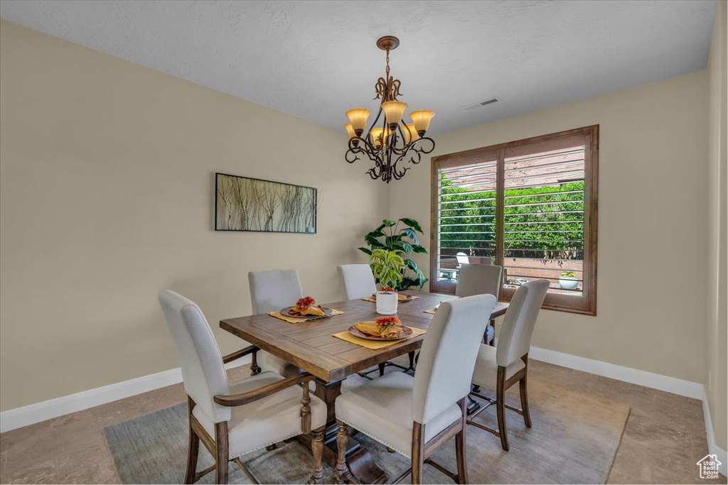 Dining area with baseboards, a notable chandelier, and visible vents