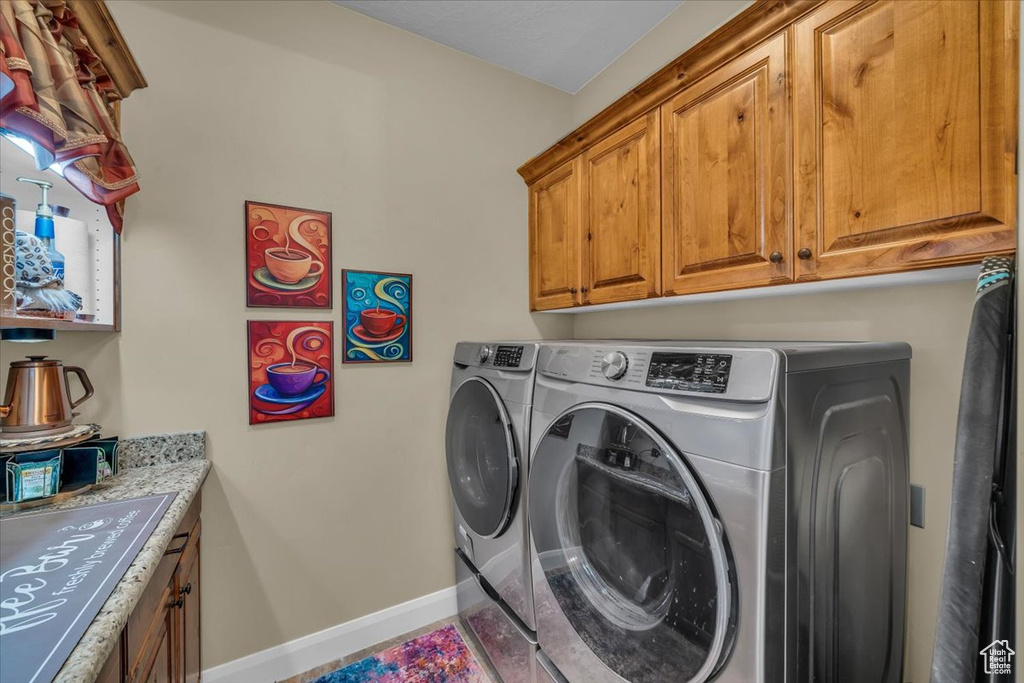 Laundry area with baseboards, washing machine and dryer, and cabinet space