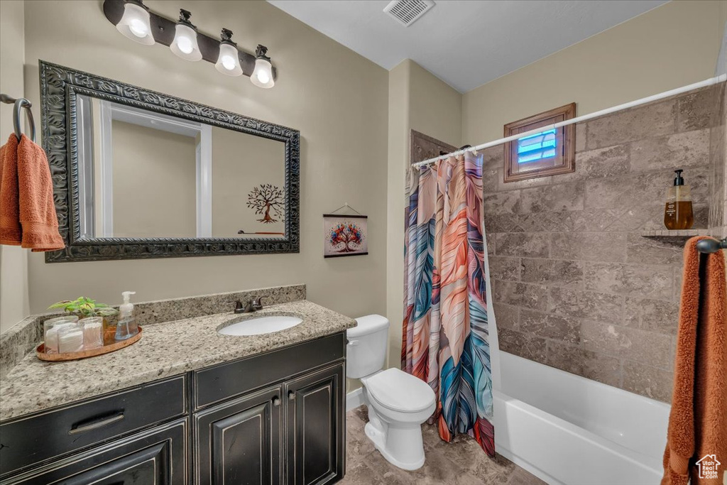 Bathroom featuring visible vents, tile patterned flooring, vanity, toilet, and shower / tub combo
