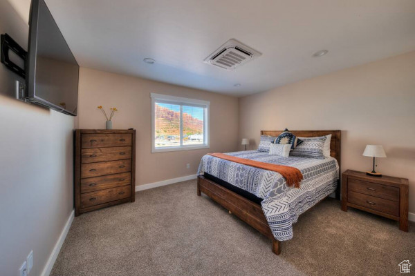 Bedroom with visible vents, baseboards, and carpet floors