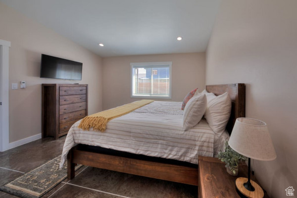 Bedroom featuring baseboards, concrete flooring, and recessed lighting