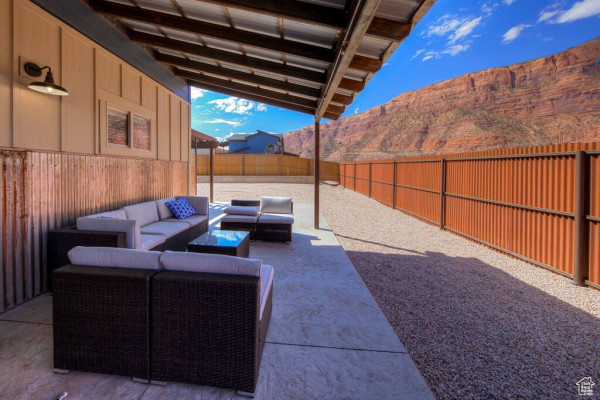 View of patio / terrace with a fenced backyard, a mountain view, and an outdoor living space