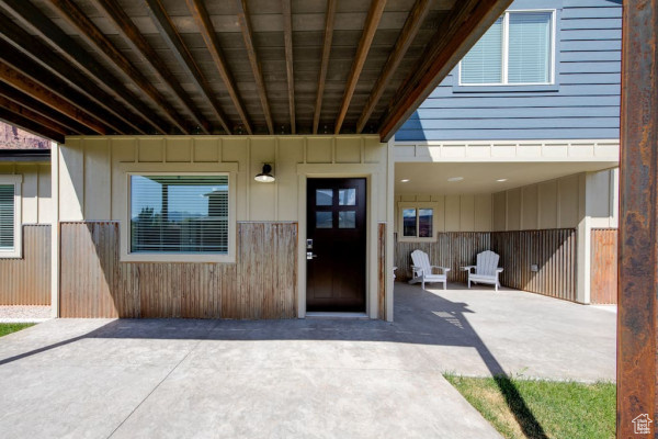 Property entrance featuring board and batten siding and a patio area