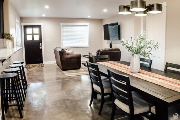Dining area with baseboards, concrete flooring, and recessed lighting