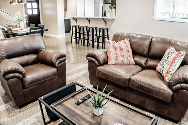 Living area featuring baseboards and concrete floors