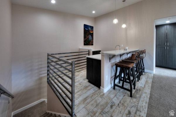 Bar featuring recessed lighting, baseboards, and pendant lighting