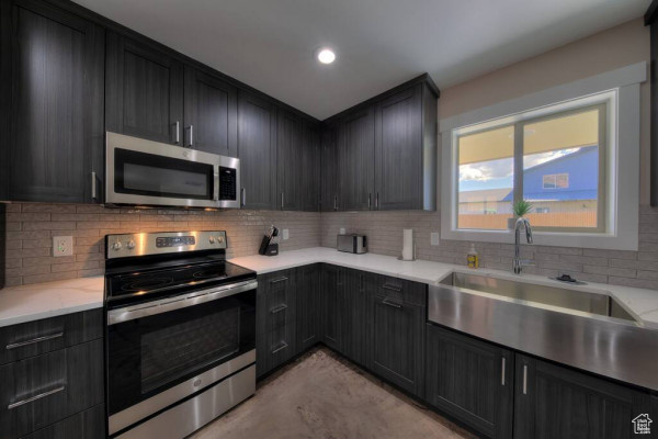 Kitchen with recessed lighting, a sink, decorative backsplash, and stainless steel appliances