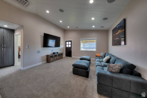 Living area featuring recessed lighting, baseboards, visible vents, and light carpet