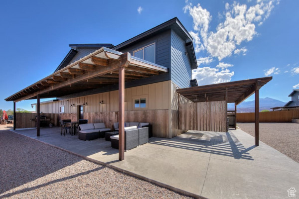 Rear view of house with a patio area, fence, and an outdoor hangout area
