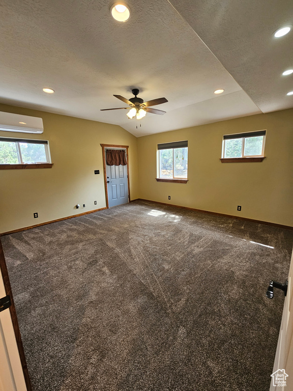 Unfurnished room featuring a wall mounted AC, plenty of natural light, recessed lighting, a ceiling fan, and carpet floors