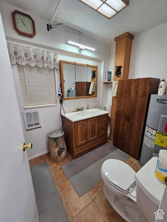 Bathroom featuring electric water heater, vanity, and toilet
