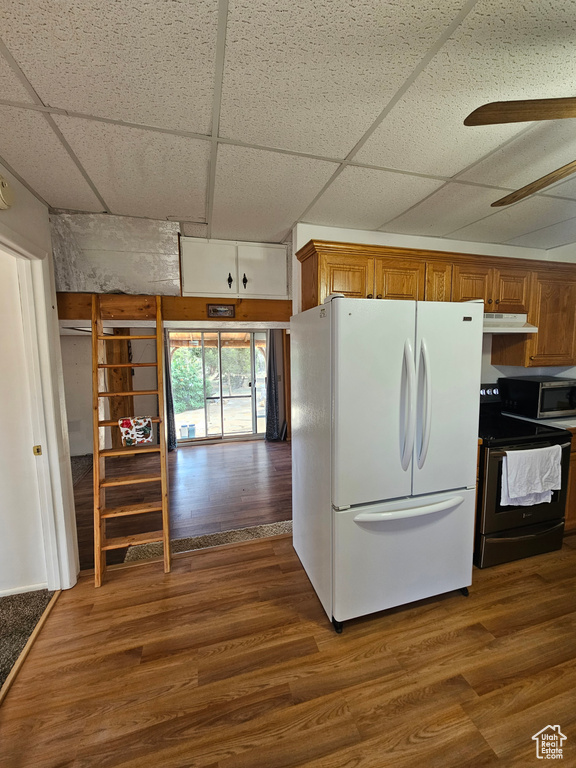 Kitchen featuring freestanding refrigerator, electric range, a paneled ceiling, stainless steel microwave, and dark wood-style floors