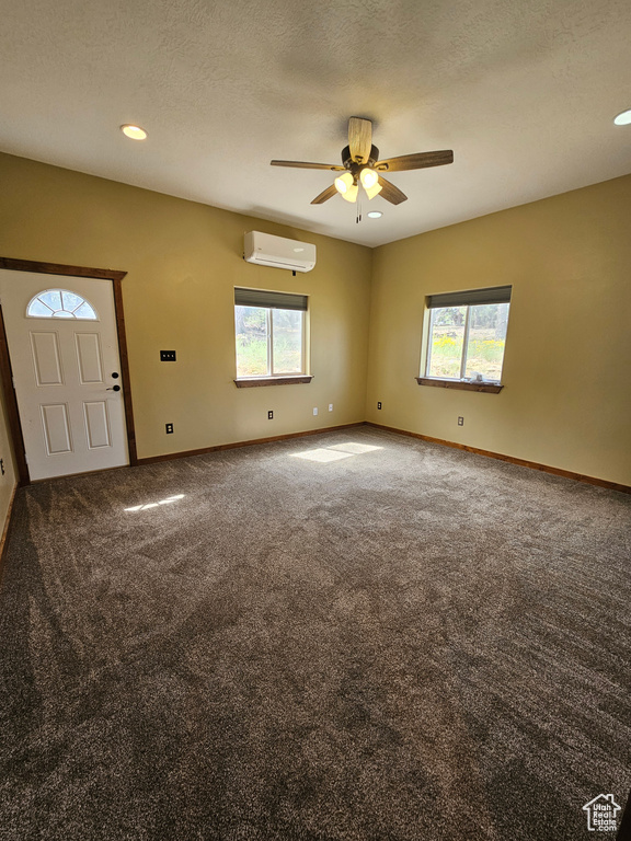 Carpeted foyer featuring a wall mounted AC, healthy amount of natural light, a ceiling fan, baseboards, and recessed lighting