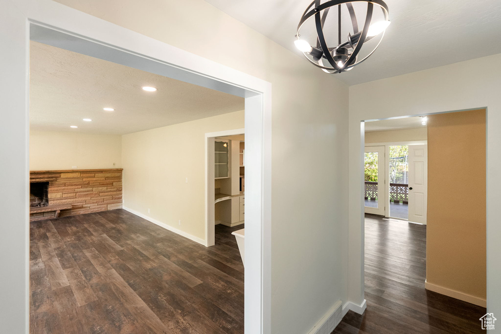 Hall with an inviting chandelier, recessed lighting, dark wood finished floors, and baseboards