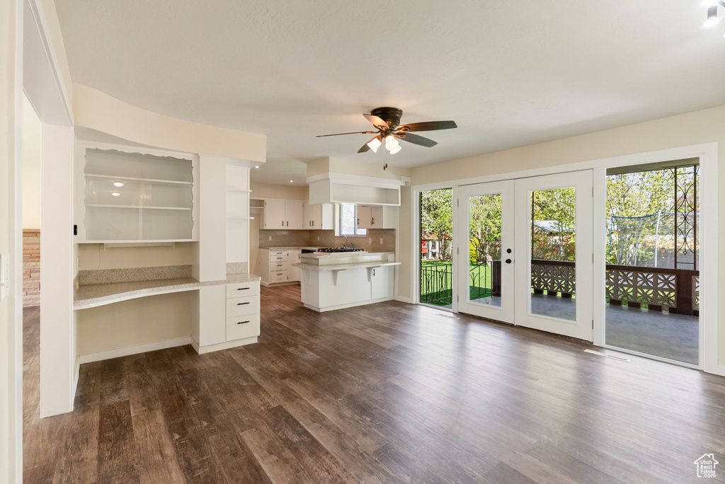 Unfurnished living room with french doors, dark wood-type flooring, and ceiling fan