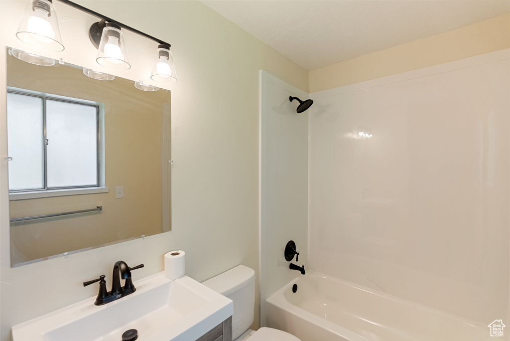 Bathroom featuring toilet, shower / tub combination, and vanity
