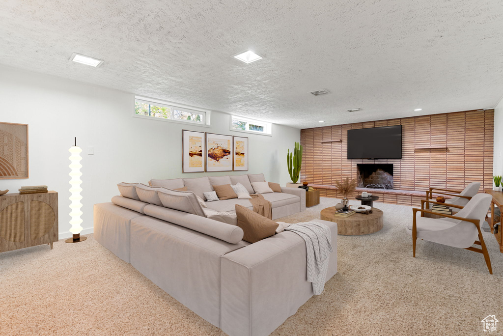 Carpeted living room with a brick fireplace, recessed lighting, and a textured ceiling