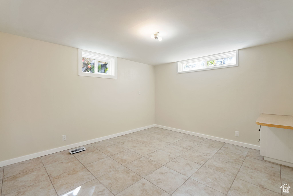 Basement featuring baseboards and light tile patterned floors