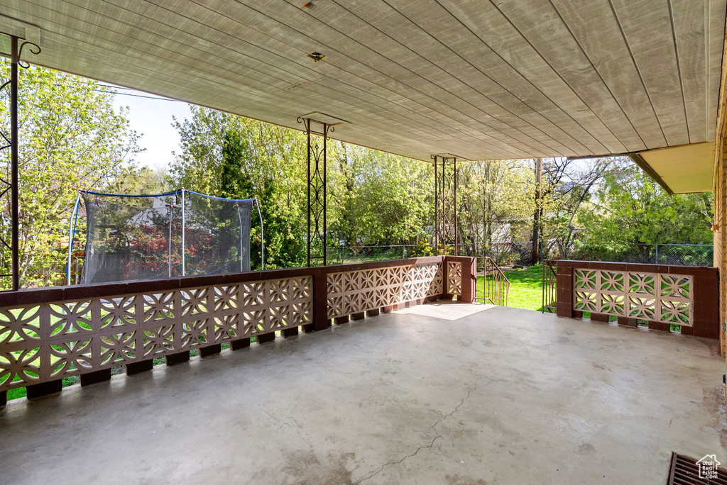 View of patio with fence and a trampoline