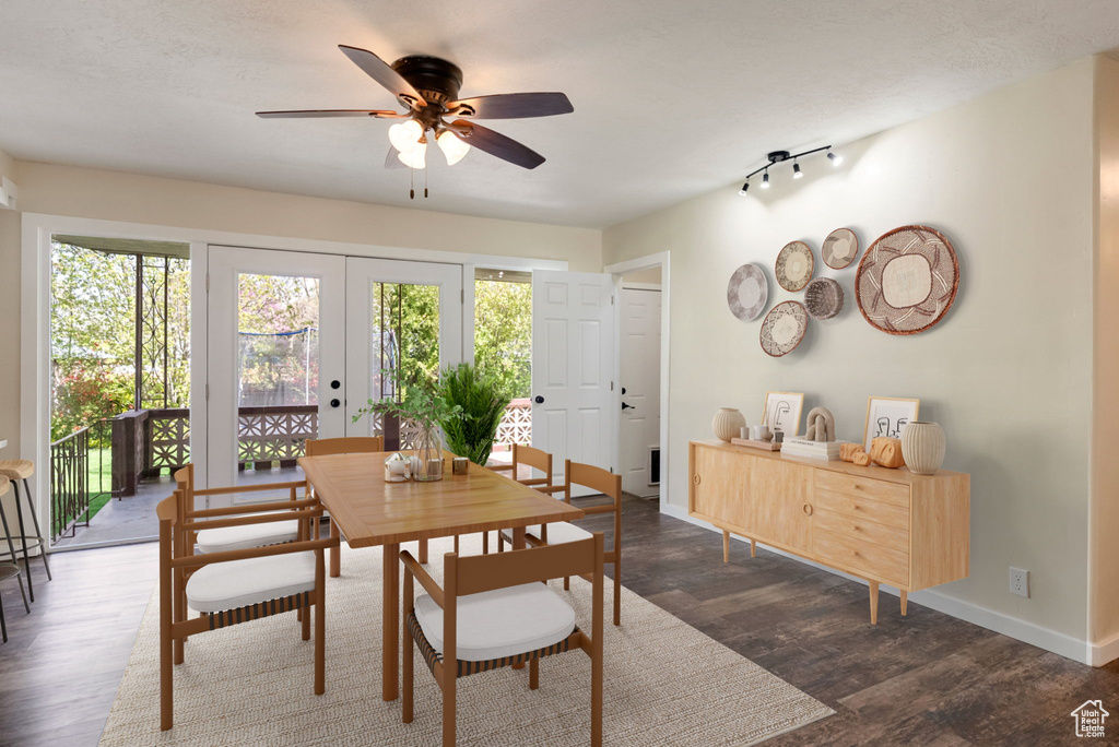 Dining space featuring french doors, plenty of natural light, a ceiling fan, and dark wood-style flooring