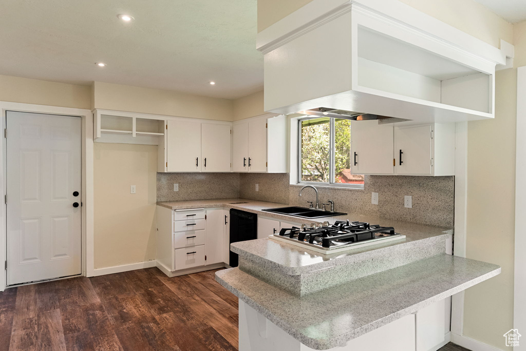 Kitchen featuring dark wood-style flooring, dishwasher, a sink, a peninsula, and stainless steel gas stovetop