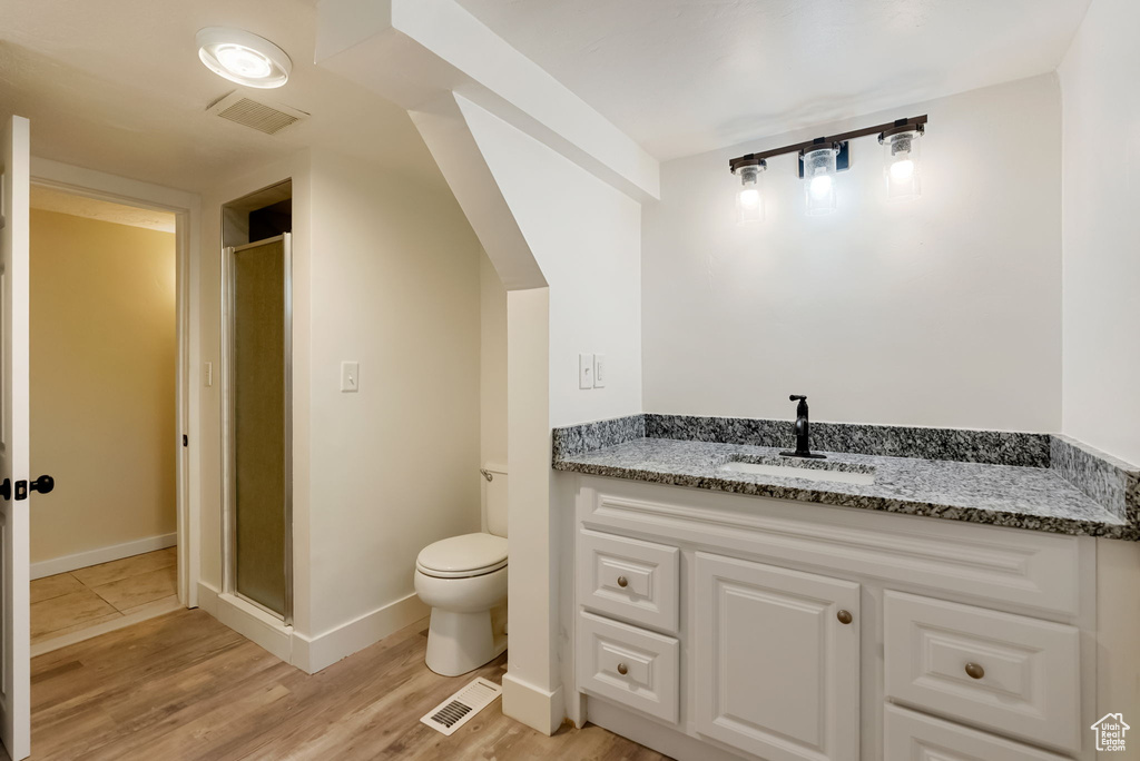 Full bath featuring toilet, visible vents, a shower stall, and wood finished floors